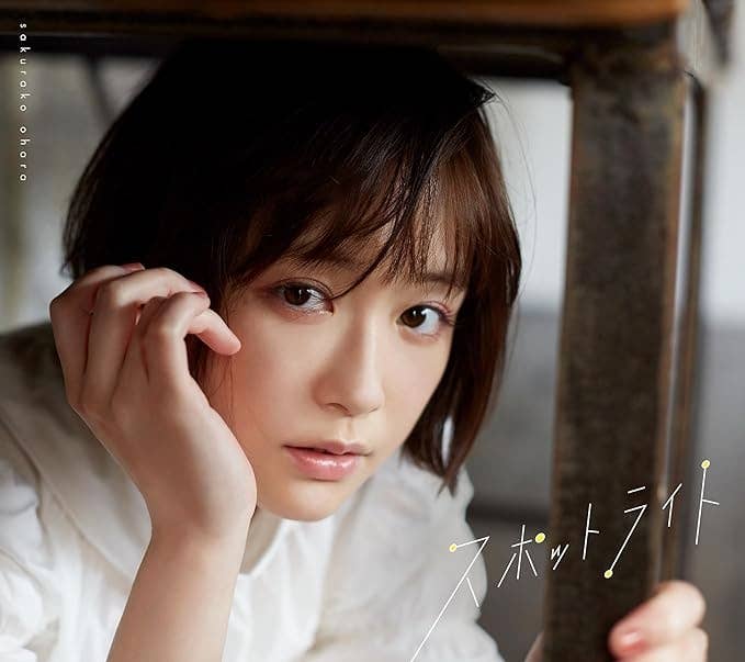 女性タレントの佐久間由衣さんが机の下から顔を覗かせている姿。