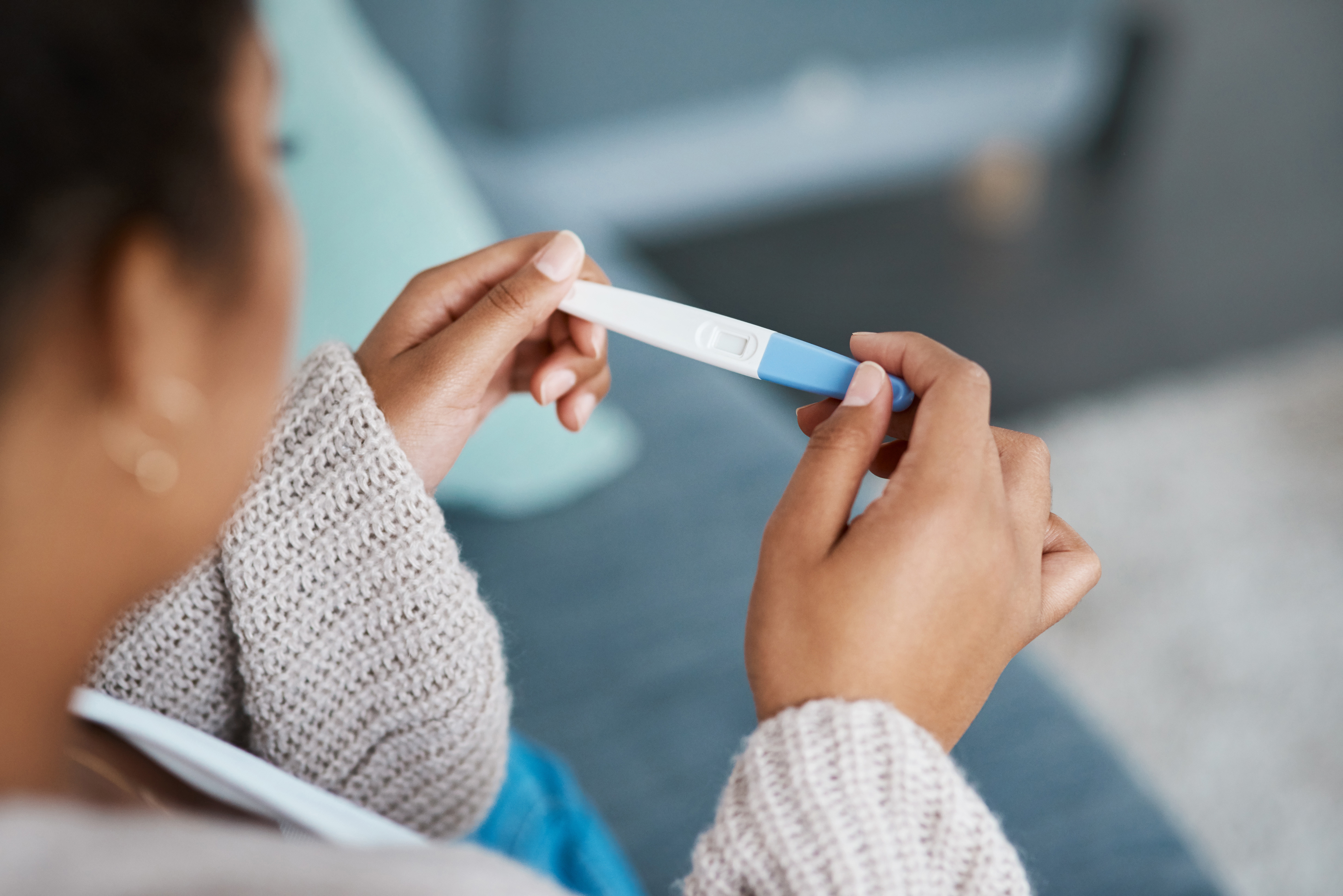 A person holds a home pregnancy test and looks at the results