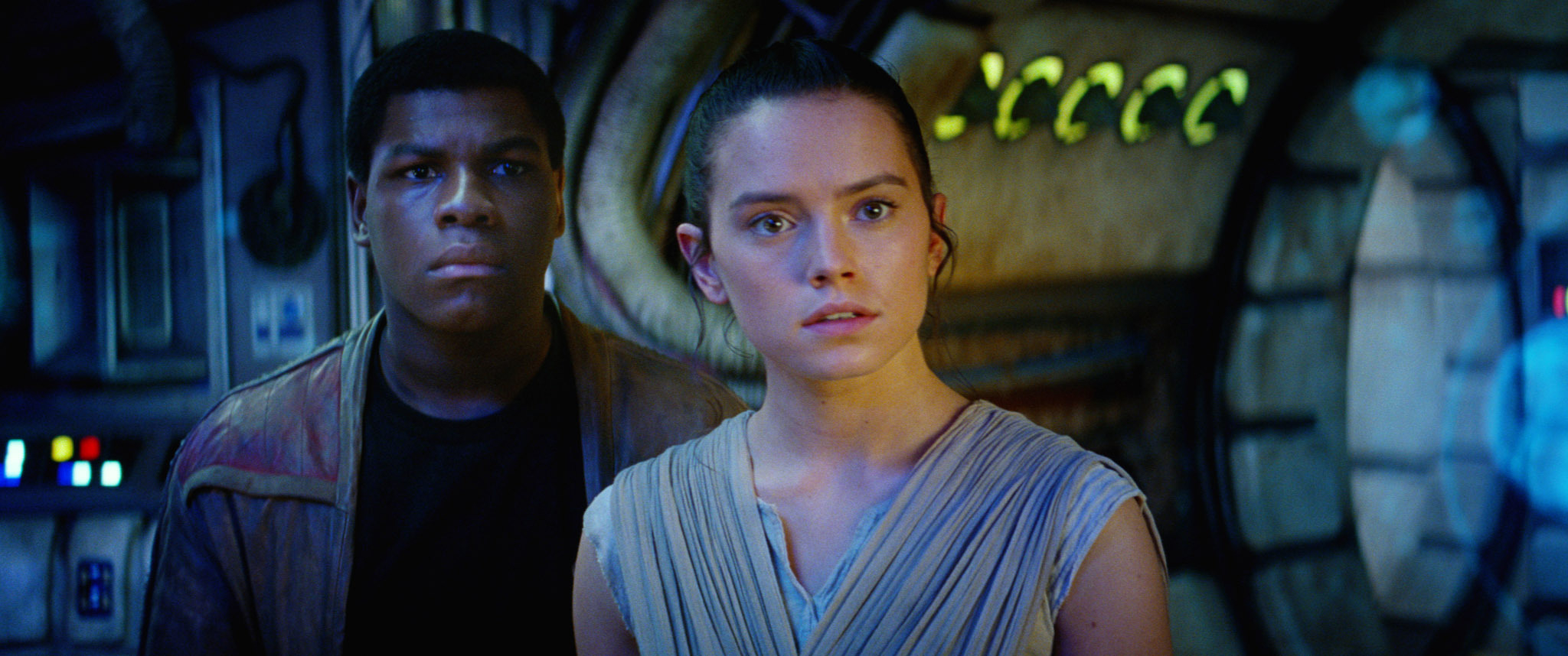 John Boyega and Daisy Ridley in sci-fi attire looking intently at something off-camera in a scene from &quot;Star Wars: The Force Awakens&quot;