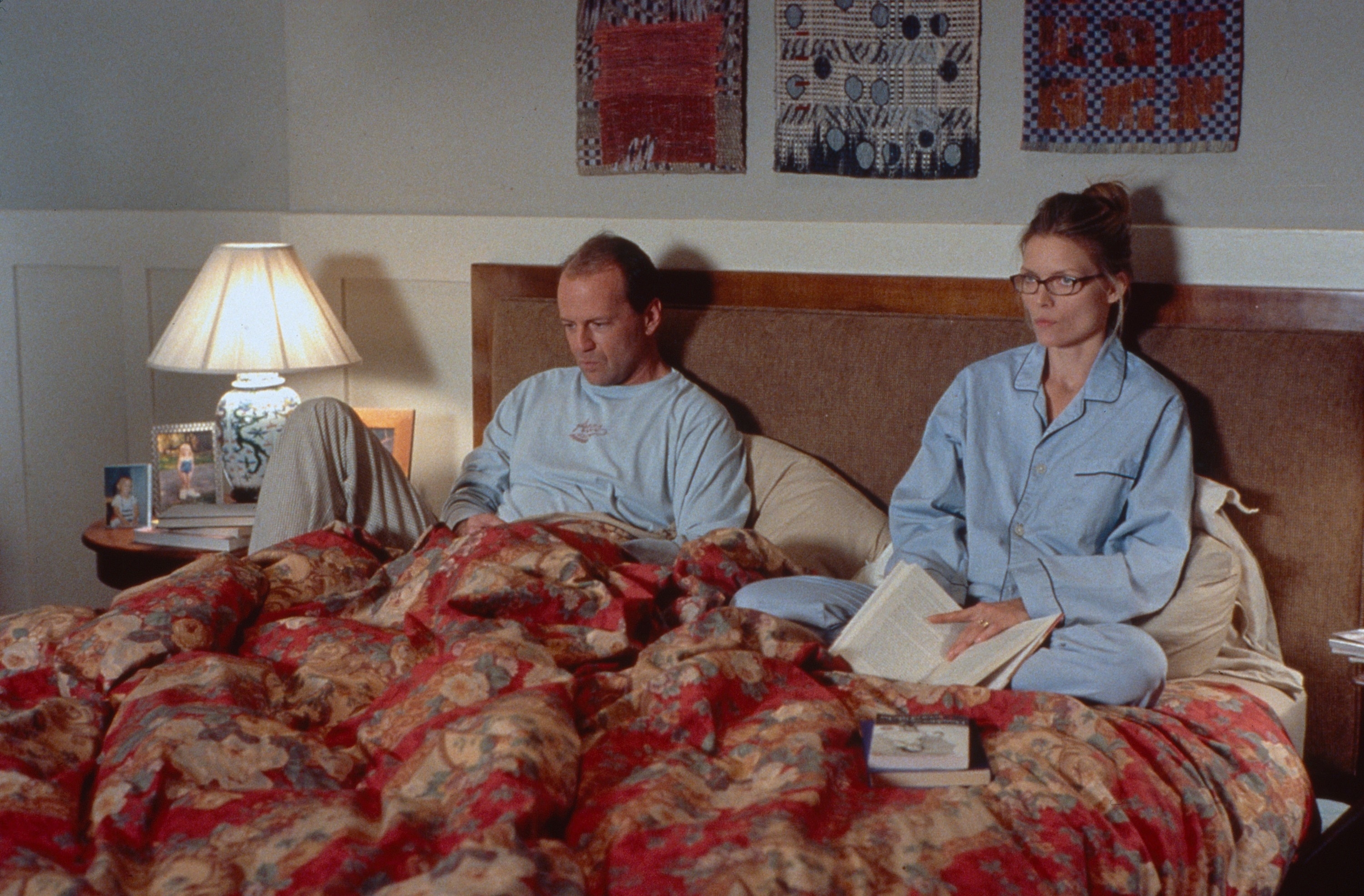 Bruce Willis and Michelle Pfeiffer from the movie &quot;The Story of Us&quot; sitting in bed, looking angry