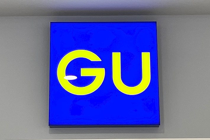 A blue sign with bright yellow letters &ldquo;G&rdquo; and &ldquo;U&rdquo; on it, likely indicating a store or brand name
