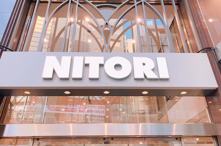ニトリの店舗の外観。建物のガラスとメタルの構造が見え、上部には「NITORI」の大きな看板が掲げられている。