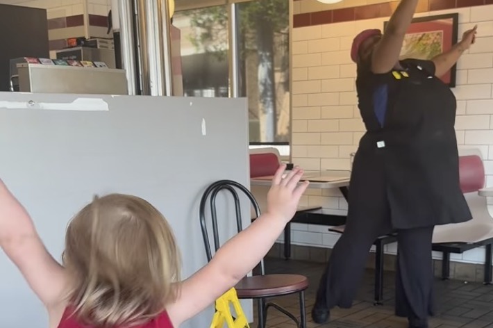 子供と店員が店内で手を挙げて楽しそうに踊っています。画面下部には「POV: You live in the greatest city in the country.」と書かれています。