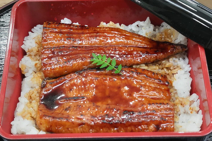 ご飯の上にタレをかけたうなぎが乗っている弁当。