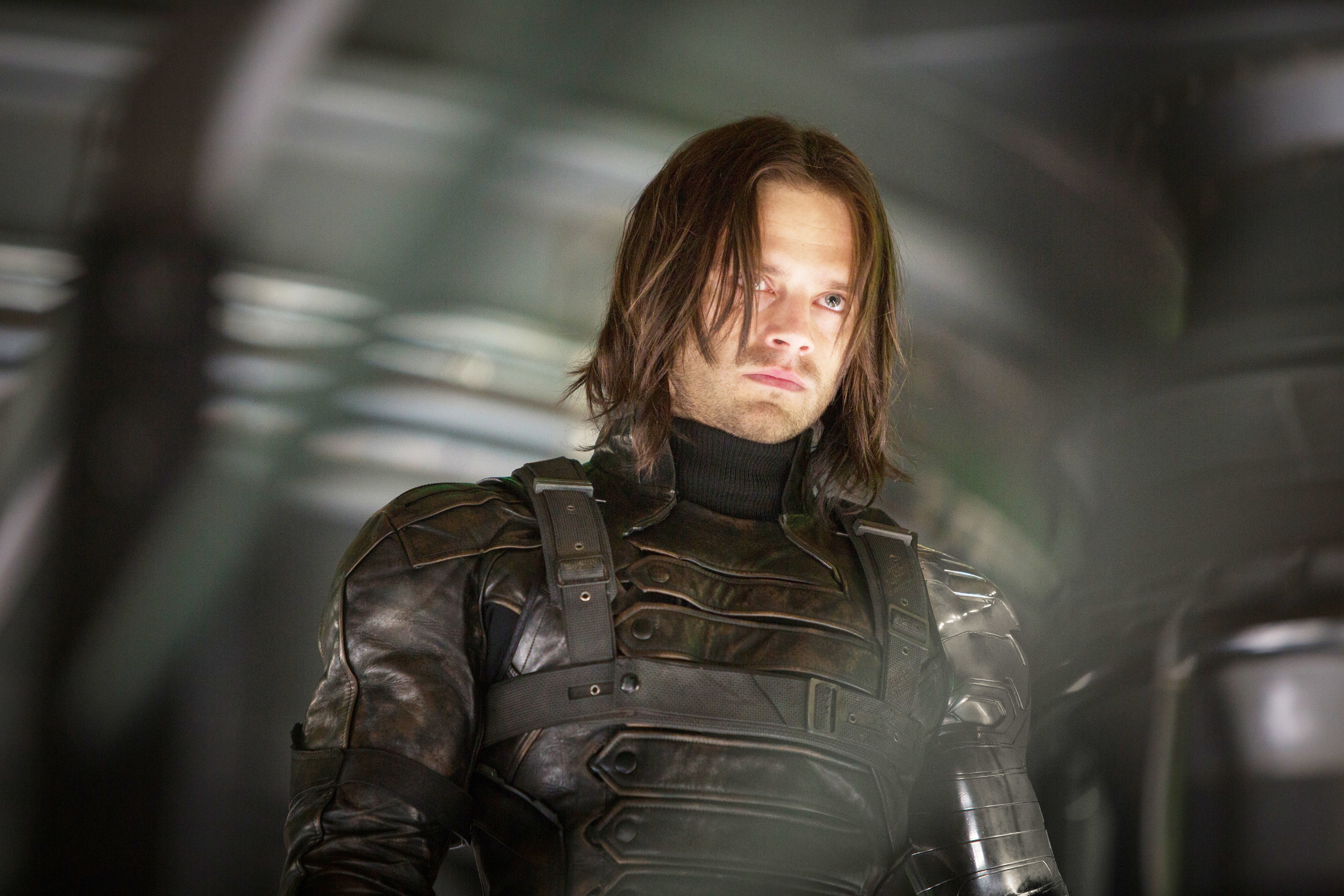 Sebastian Stan as Bucky Barnes in a scene from a movie, wearing tactical armor with a serious expression