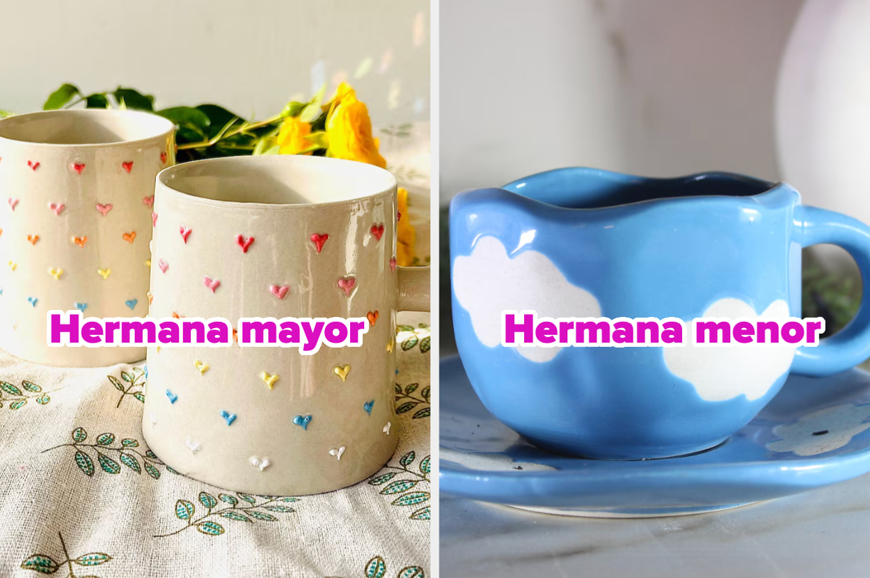 Dos tazas de cerámica: una blanca con corazones bordados etiquetada "Hermana mayor", otra azul con nubes etiquetada "Hermana menor"
