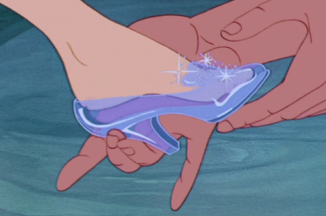 Cinderella's foot being fitted into a glass slipper with sparkles showing the perfect fit