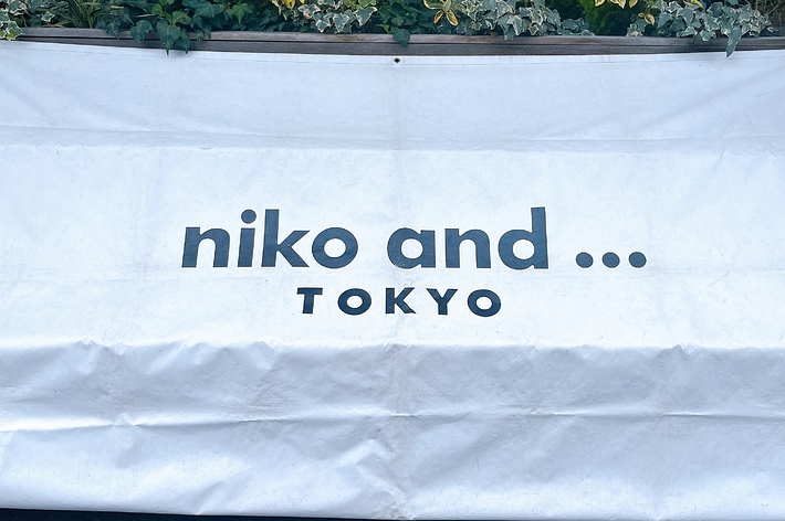 白い幕に黒い文字で「niko and … TOKYO」と書かれている。