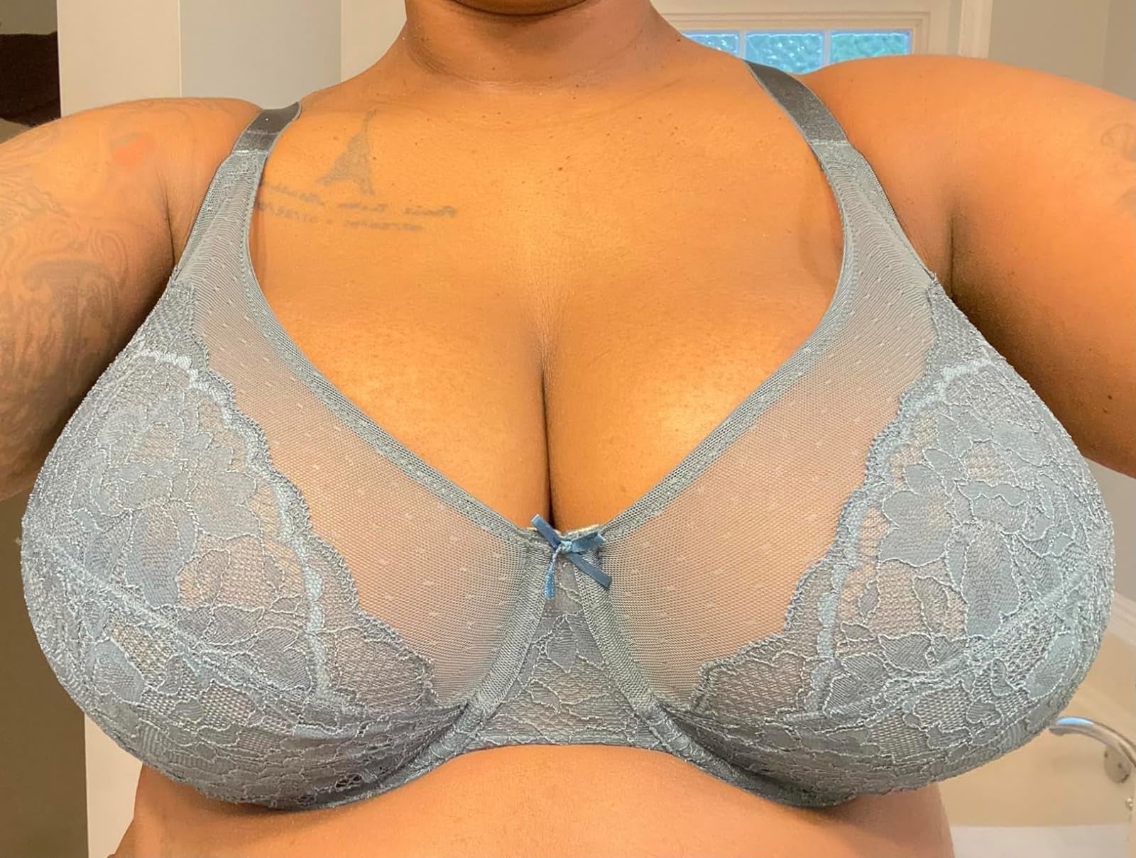 A idiosyncratic   wearing a lace bra, facing guardant  and taking a selfie successful  beforehand   of a mirror