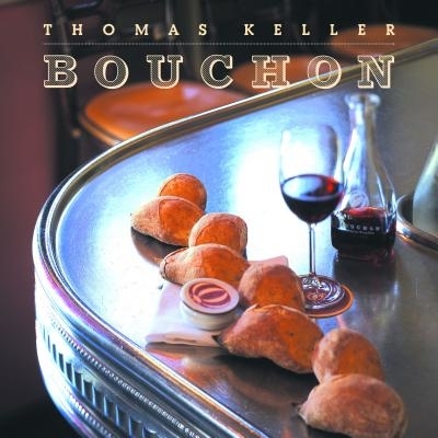 Cover of the cookbook "Bouchon" by Thomas Keller, featuring fresh bread and a glass of red wine on a bar counter