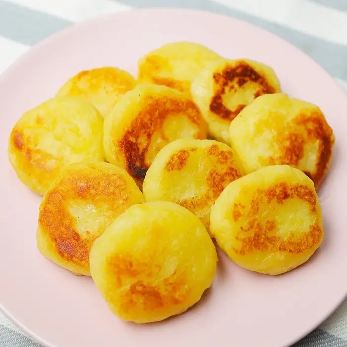 皿に盛られた焼き色がついた丸いポテトパンケーキが並んでいます。