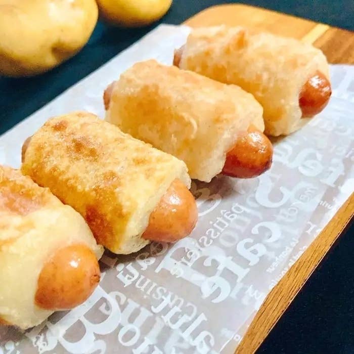 陪仕用のパン生地で包まれた小さなホットドッグが4つ並んでます。