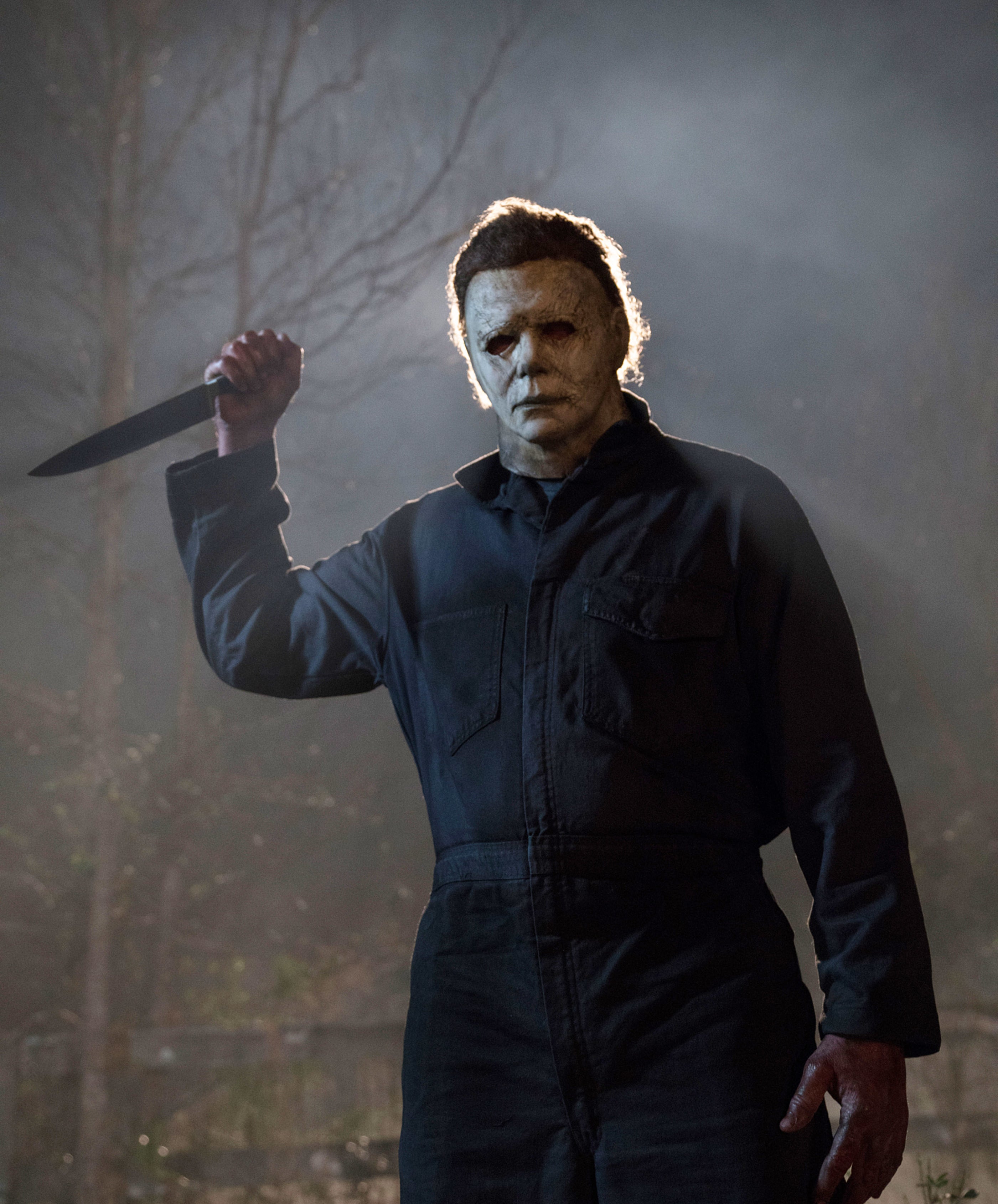 Michael Myers holding a knife, wearing a mask and dark coveralls, in a scene from &quot;Halloween&quot;