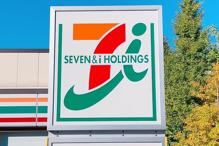 セブン&amp;アイ・ホールディングスの看板が表示されています。高層の木々が背景に見えます。