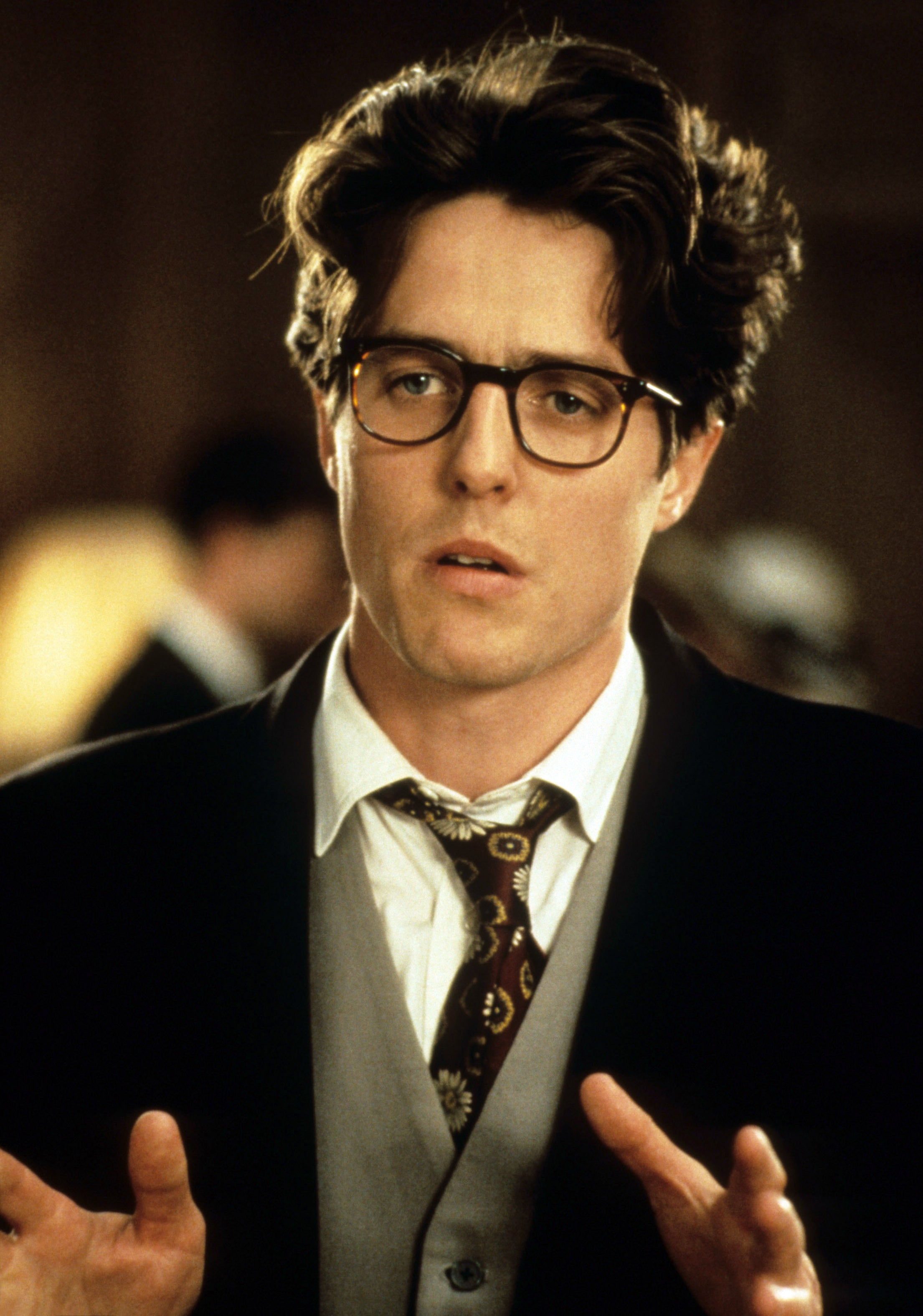 Hugh Grant in a suit and tie in a scene from "Four Weddings and a Funeral"