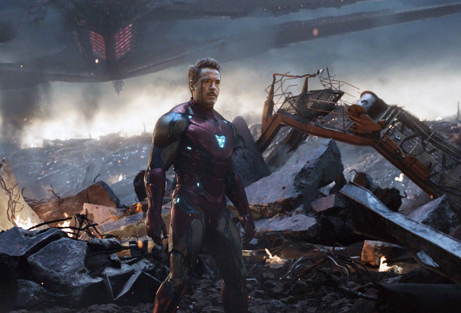 Iron Man, played by Robert Downey Jr., stands in a devastated battleground scene in "Avengers: Endgame"