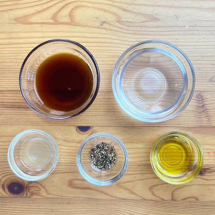 木製のテーブルに並べられた5つのガラス容器に調味料が入れられている。