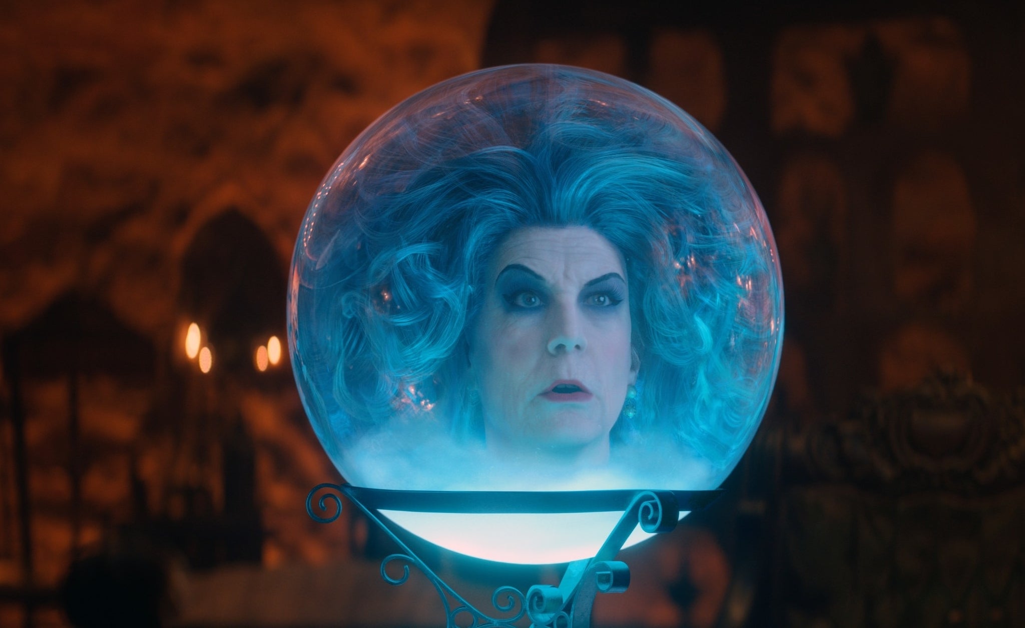 Jamie Lee Curtis as Madame Leota in a crystal ball, with ethereal blue hair and an eerie background in a scene from &quot;Haunted Mansion&quot;