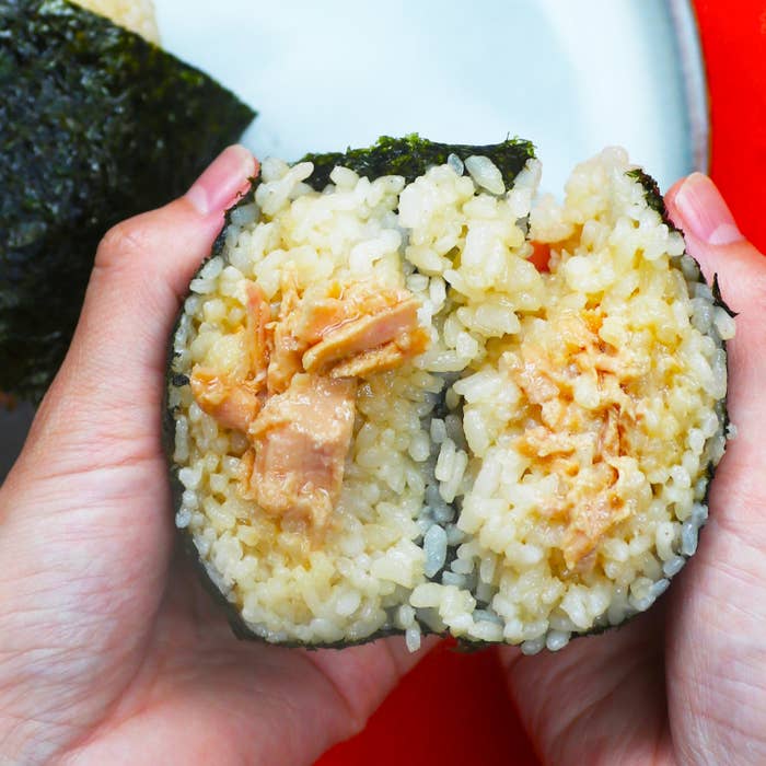 手に持たれたおにぎりのクローズアップ。