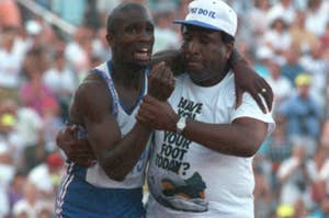 Derek Redmond, a track and field athlete, is being helped by his father, Jim Redmond, after an injury during a race. Both are emotional and holding each other