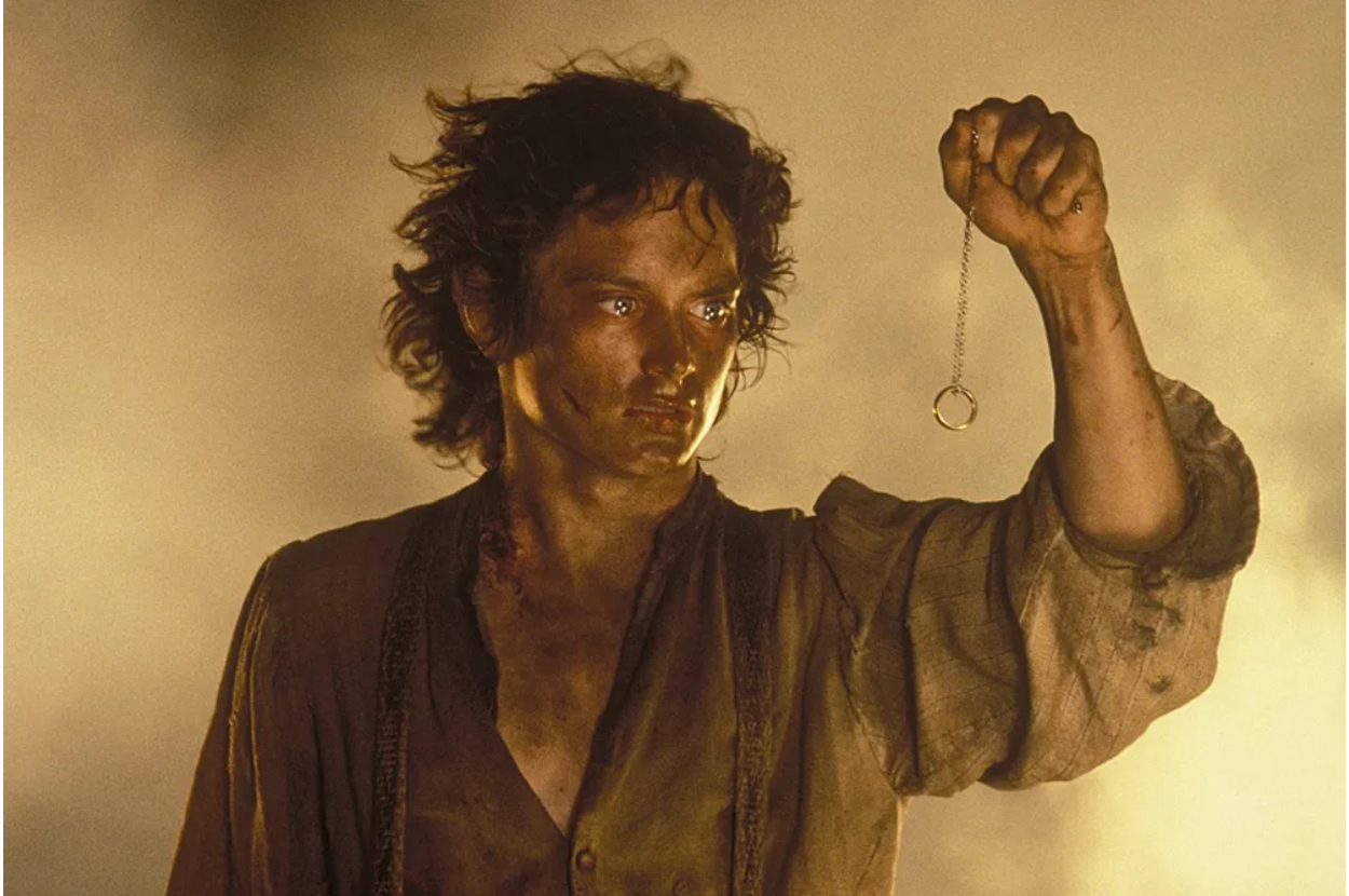 Elijah Wood as Frodo Baggins holding the One Ring on a chain in a scene from "The Lord of the Rings" film series