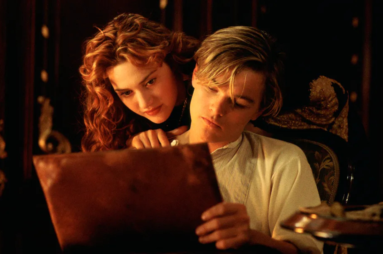 Kate Winslet and Leonardo DiCaprio in a scene from the movie Titanic. They are closely looking at a drawing together