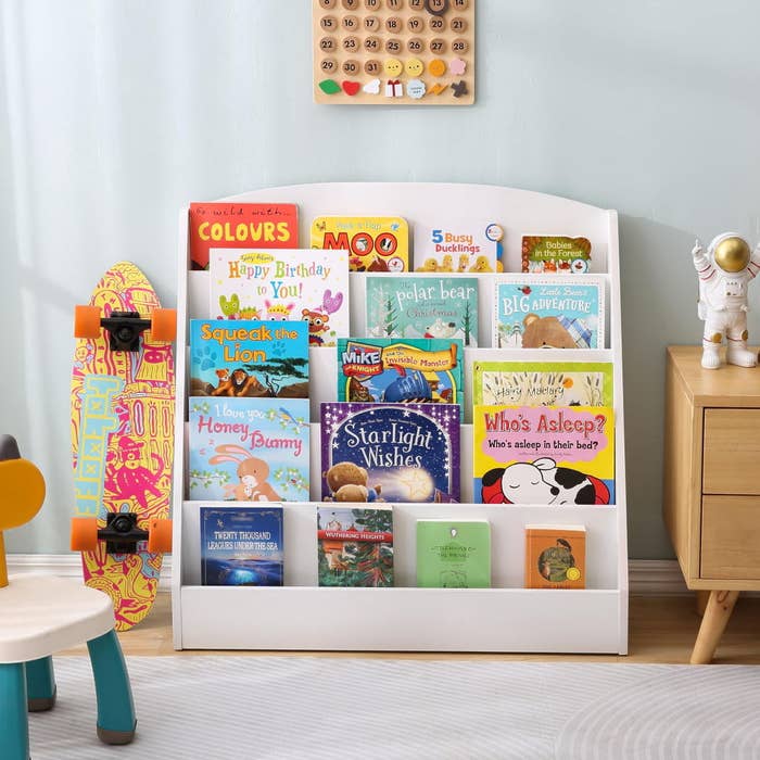 Bookshelf with children's books, a skateboard, and a decorative astronaut figurine. Featured books include "Starlight Wishes," "The Big Adventure," and "Happy Birthday, Mike!"