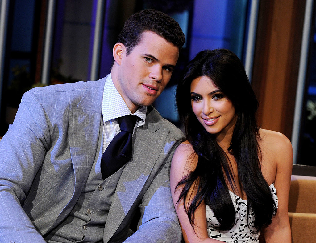 Kim Kardashian in a strapless dress sitting close to Kris Humphries in a suit and tie, smiling