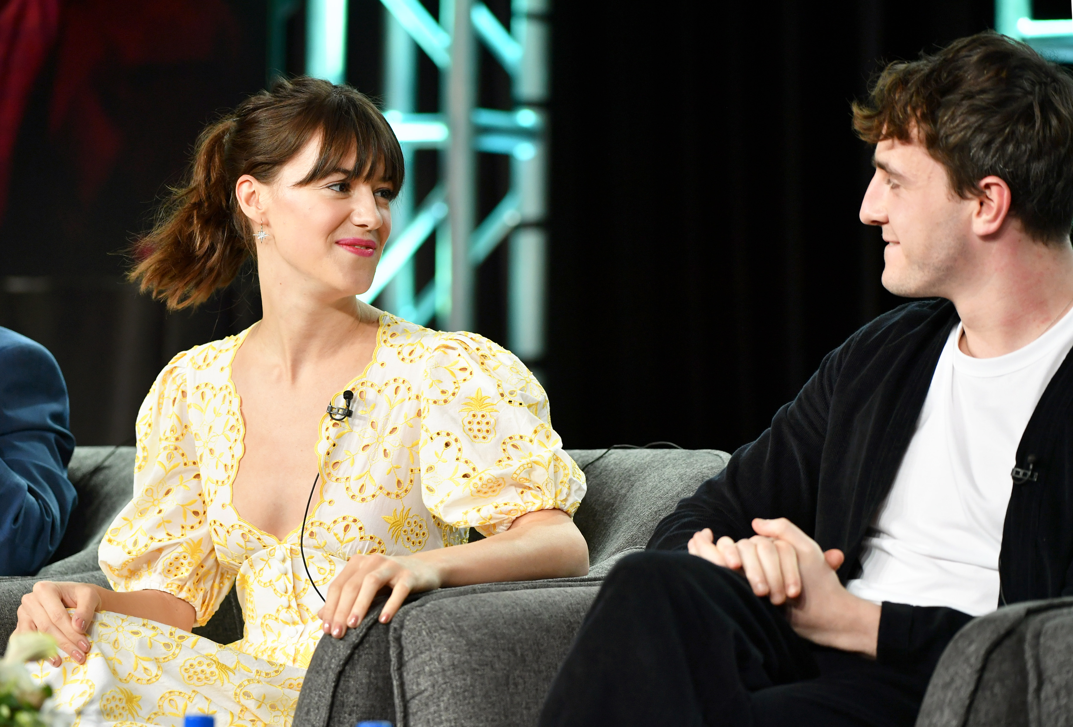 Daisy Edgar-Jones in a floral dress and Paul Mescal in dark casualwear seated and looking at each other during a press event