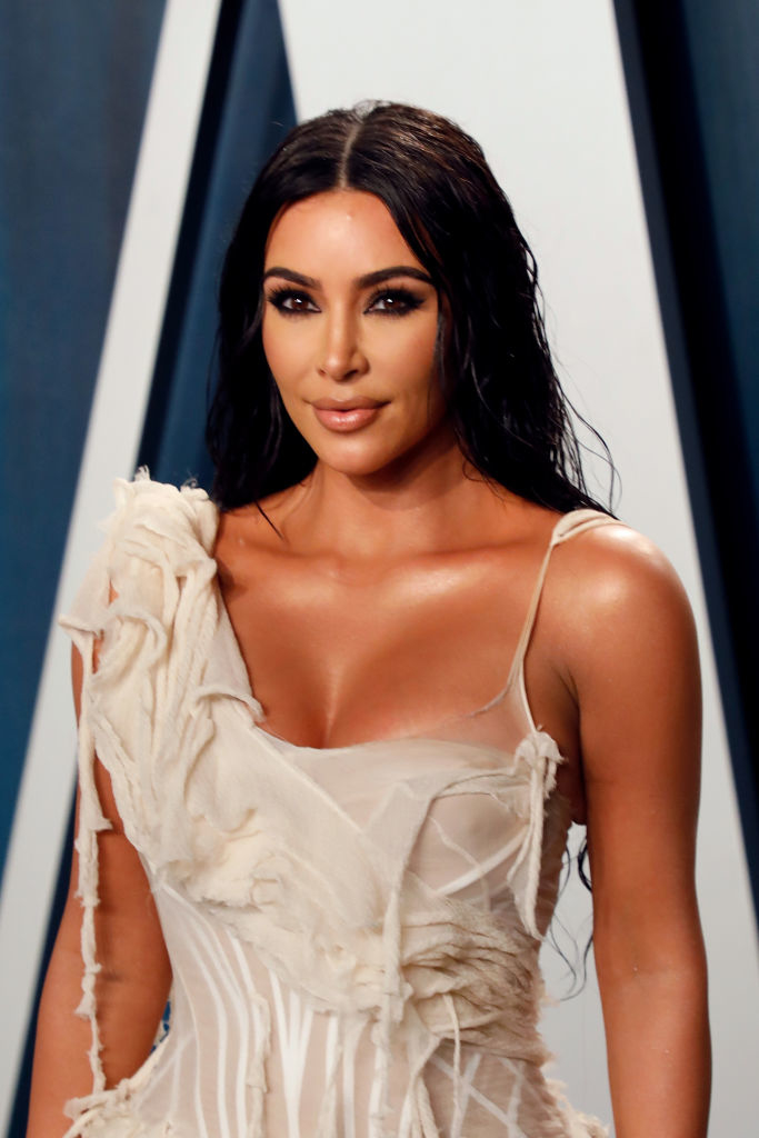 Kim Kardashian at a red carpet event, dressed in an elegant, intricate gown with asymmetrical design details