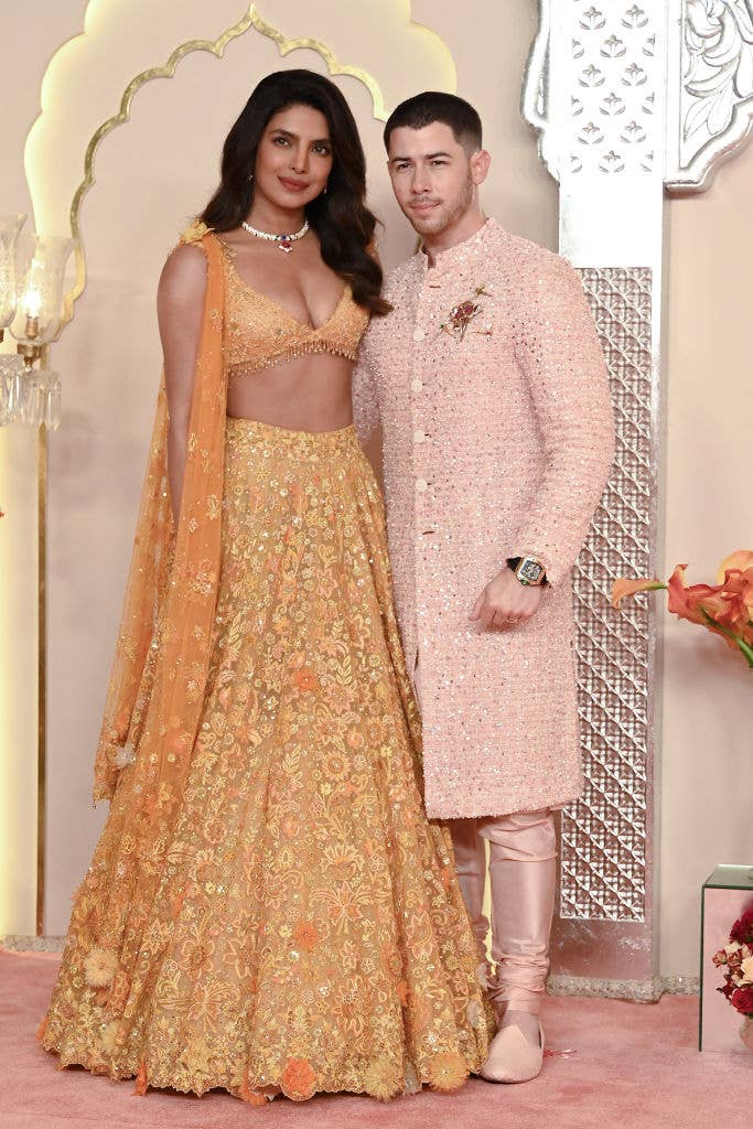 Priyanka Chopra in an embroidered lehenga and Nick Jonas in a traditional sherwani, posing together at a formal event