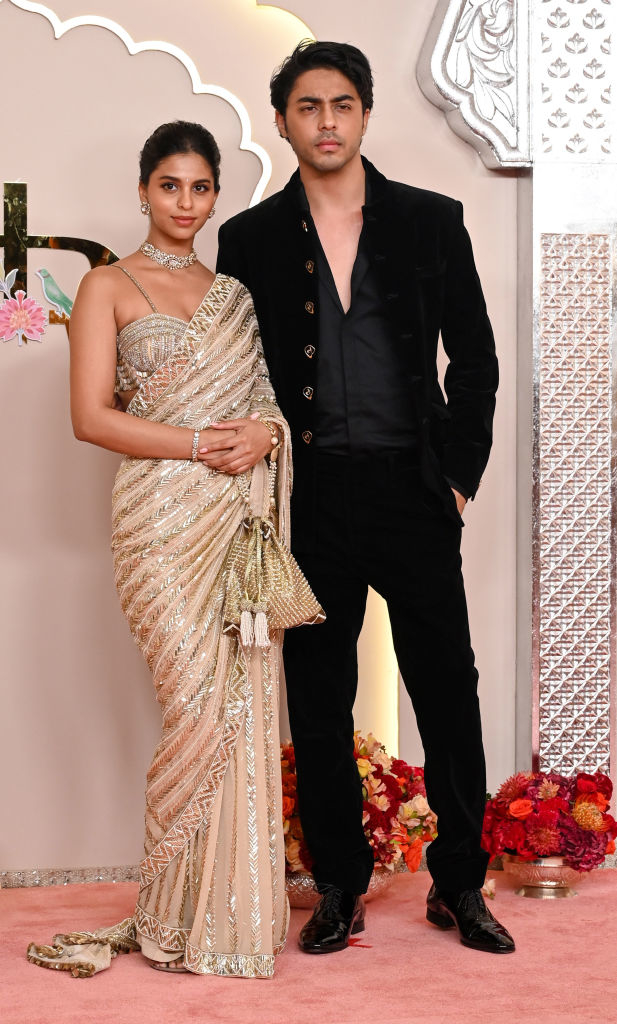 Suhana Khan in an ornate saree and Aryan Khan in a suit posing together at an event