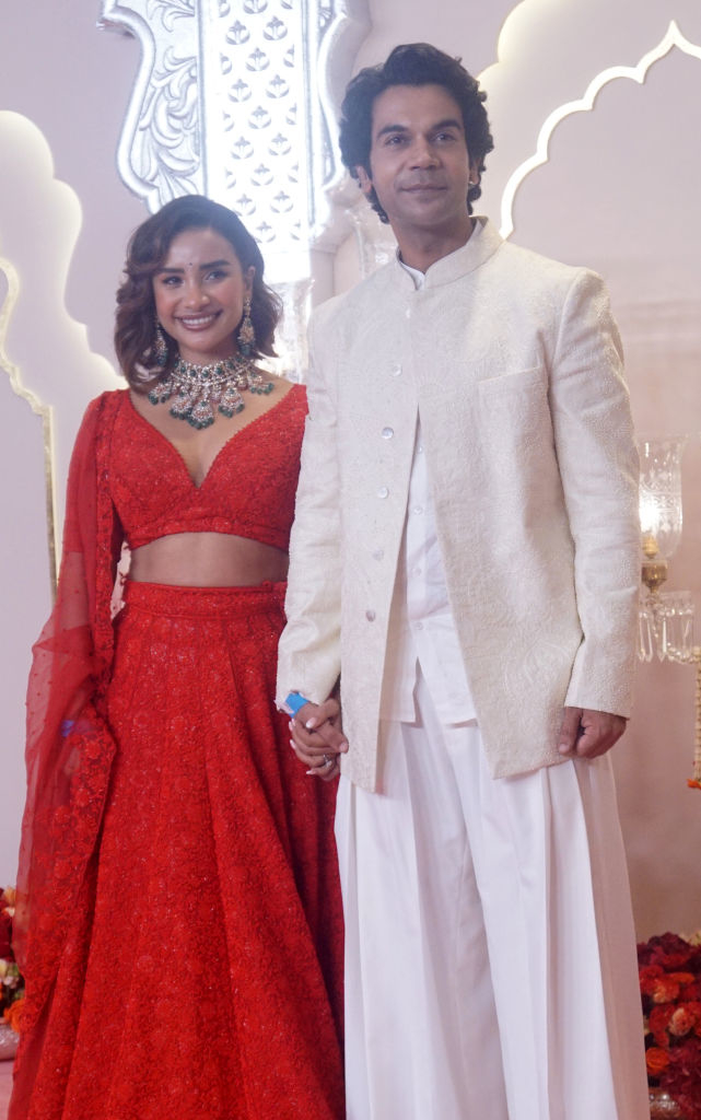 Rajkummar Rao wearing a sherwani and Patralekhaa in a traditional lehenga, smiling and holding hands on a special occasion