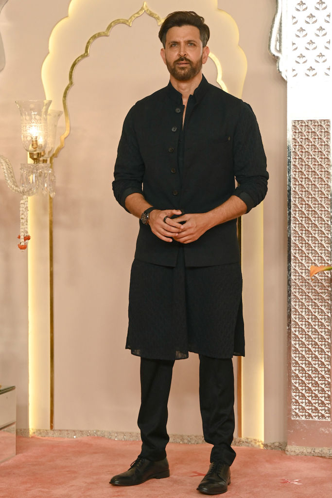 Hrithik Roshan stands in traditional formal attire, featuring a long kurta and pants, at a formal event