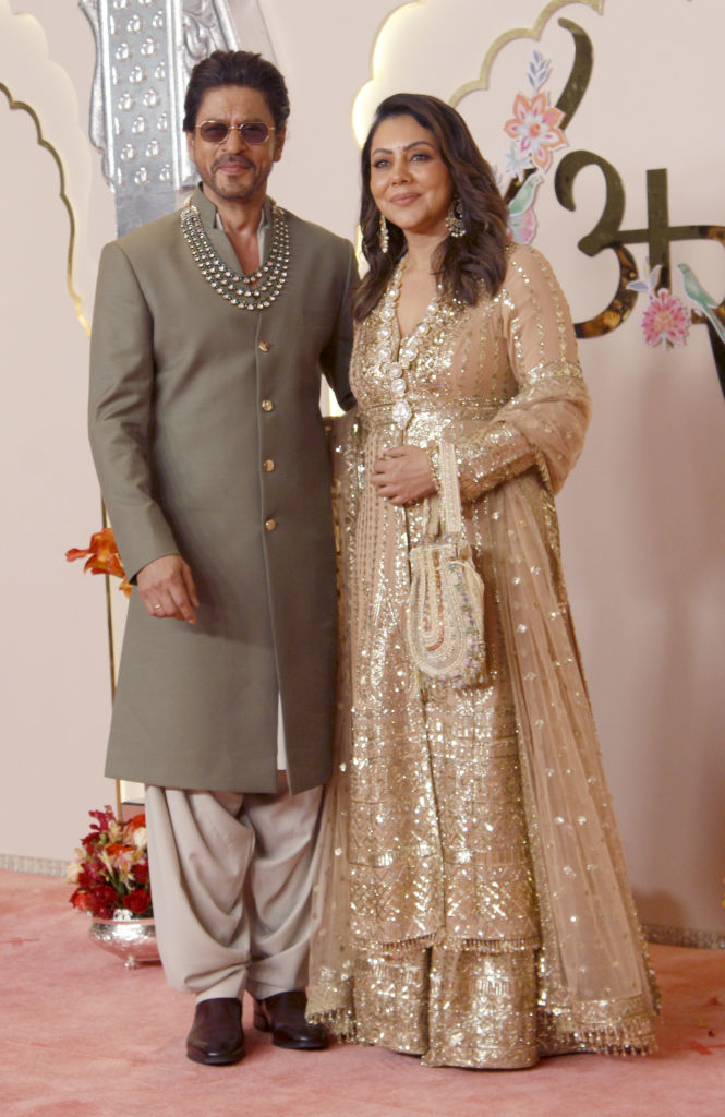 Shah Rukh Khan in a traditional outfit with a pearl necklace and Gauri Khan in an embroidered gown on the red carpet