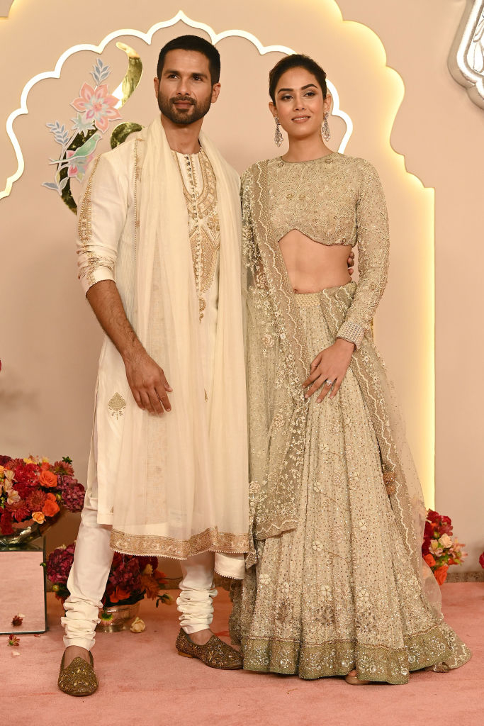 Shahid Kapoor and Mira Rajput pose together in traditional Indian attire at an event, with Shahid in a kurta and Mira in an embellished lehenga