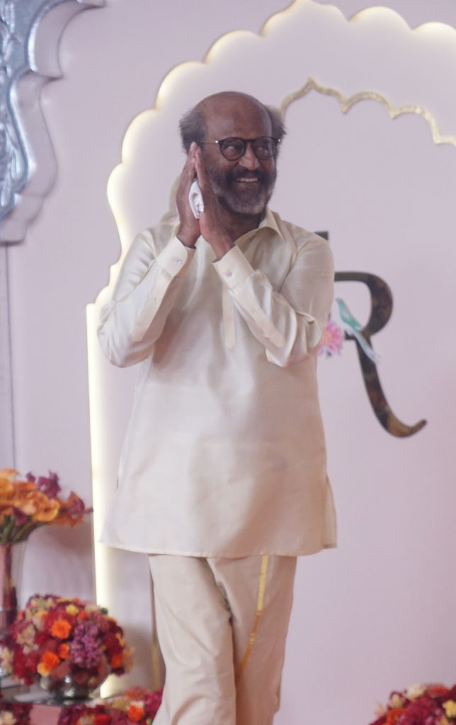 Rajinikanth, wearing a traditional outfit, stands with hands together in a greeting pose at an event