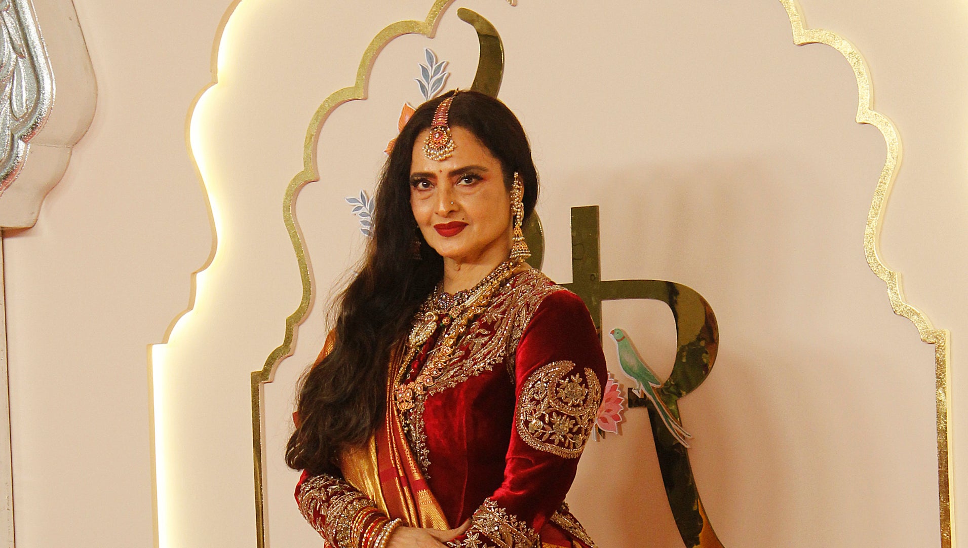 Rekha stands on the red carpet wearing a traditional silk saree, adorned with intricate jewelry, at a formal event