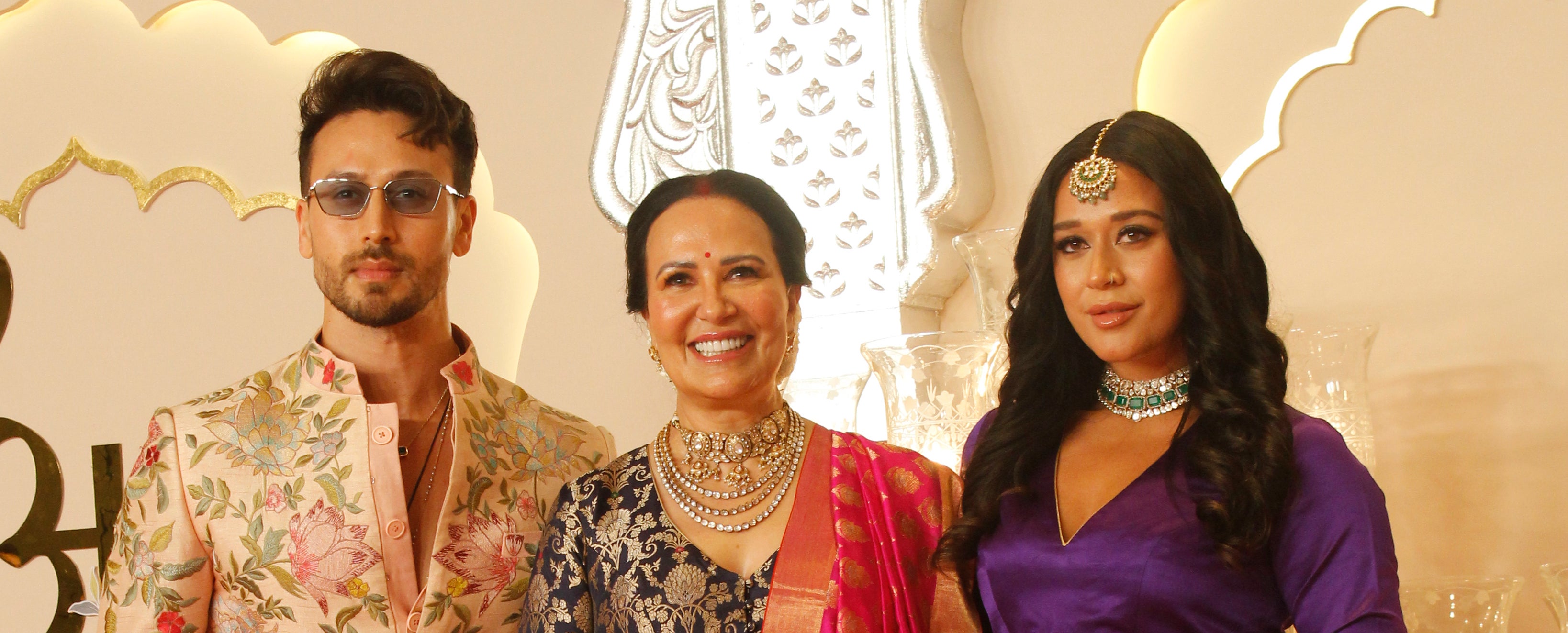 Tiger Shroff, Ayesha Shroff, and Krishna Shroff pose on a red carpet in traditional Indian attire