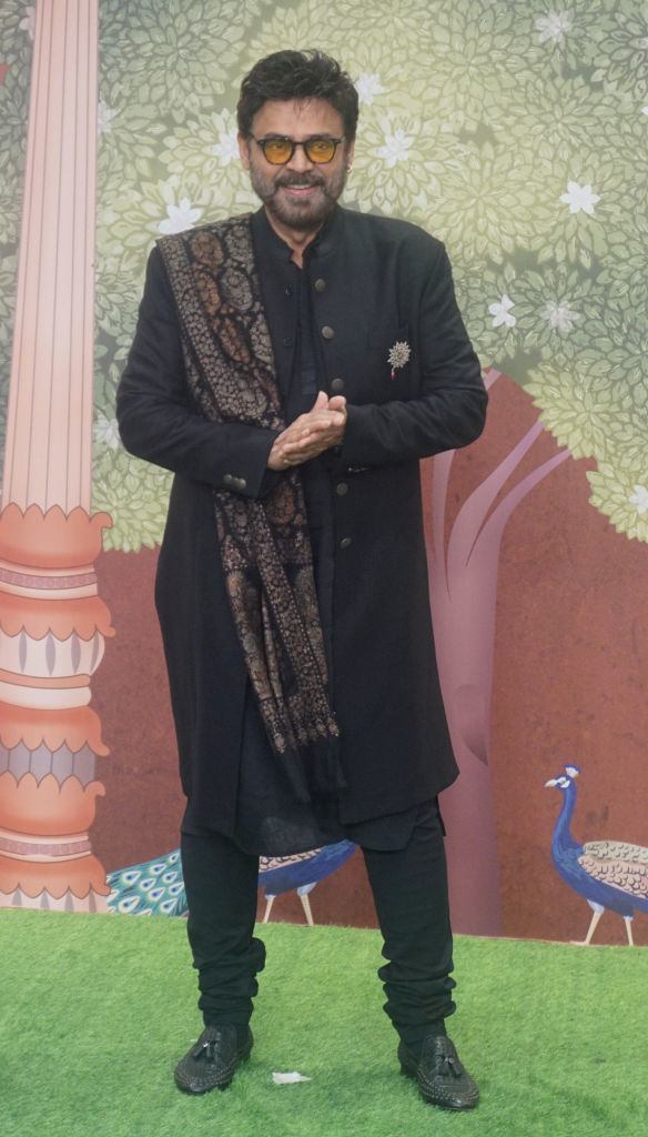 Daggubati Venkatesh stands on a grass-like carpet wearing a traditional sherwani with a patterned shawl over his shoulder