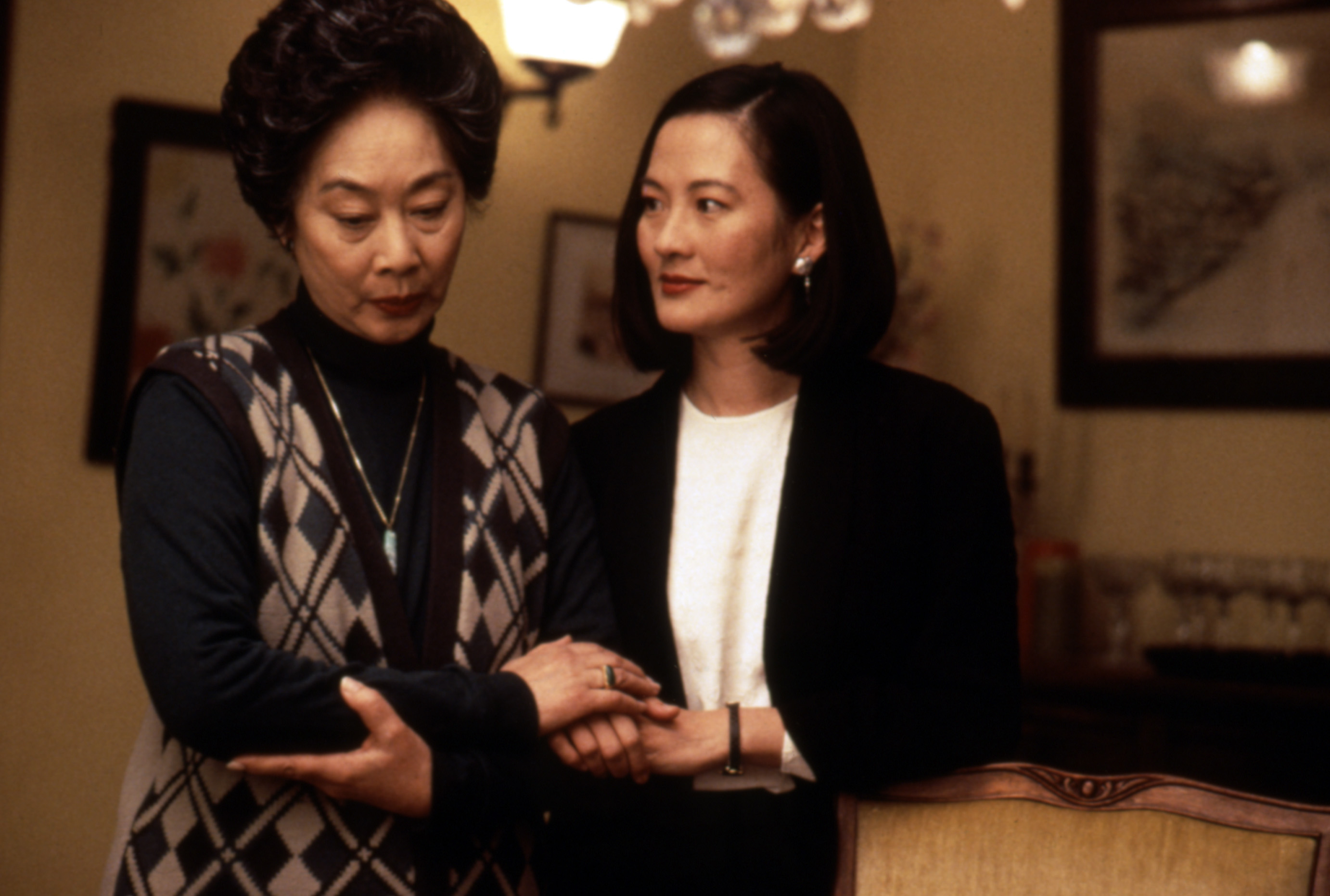Ming-Na Wen and Tsai Chin in an indoor scene from "The Joy Luck Club," with Ming-Na Wen holding Tsai Chin's arm, showing an emotional conversation
