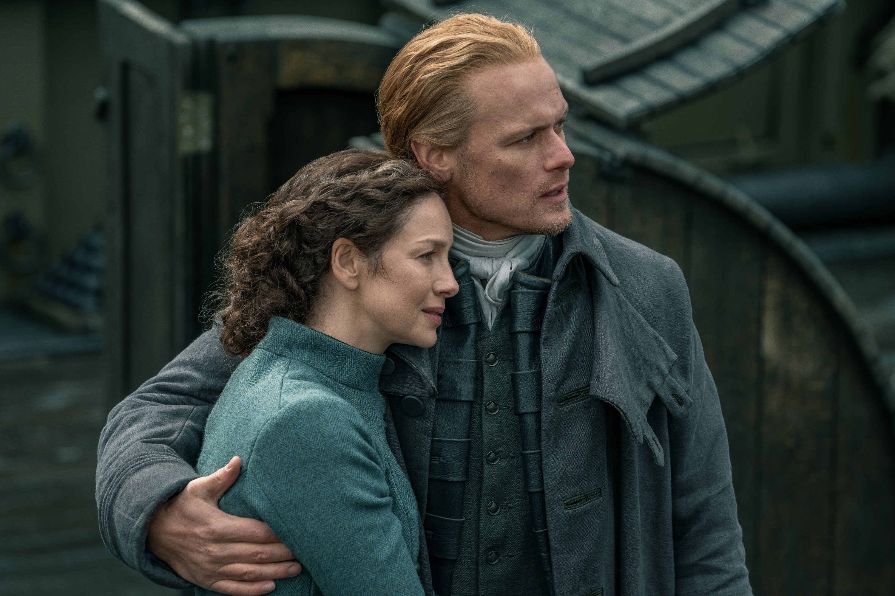 Caitriona Balfe and Sam Heughan in a scene from "Outlander," embracing while dressed in 18th-century period attire
