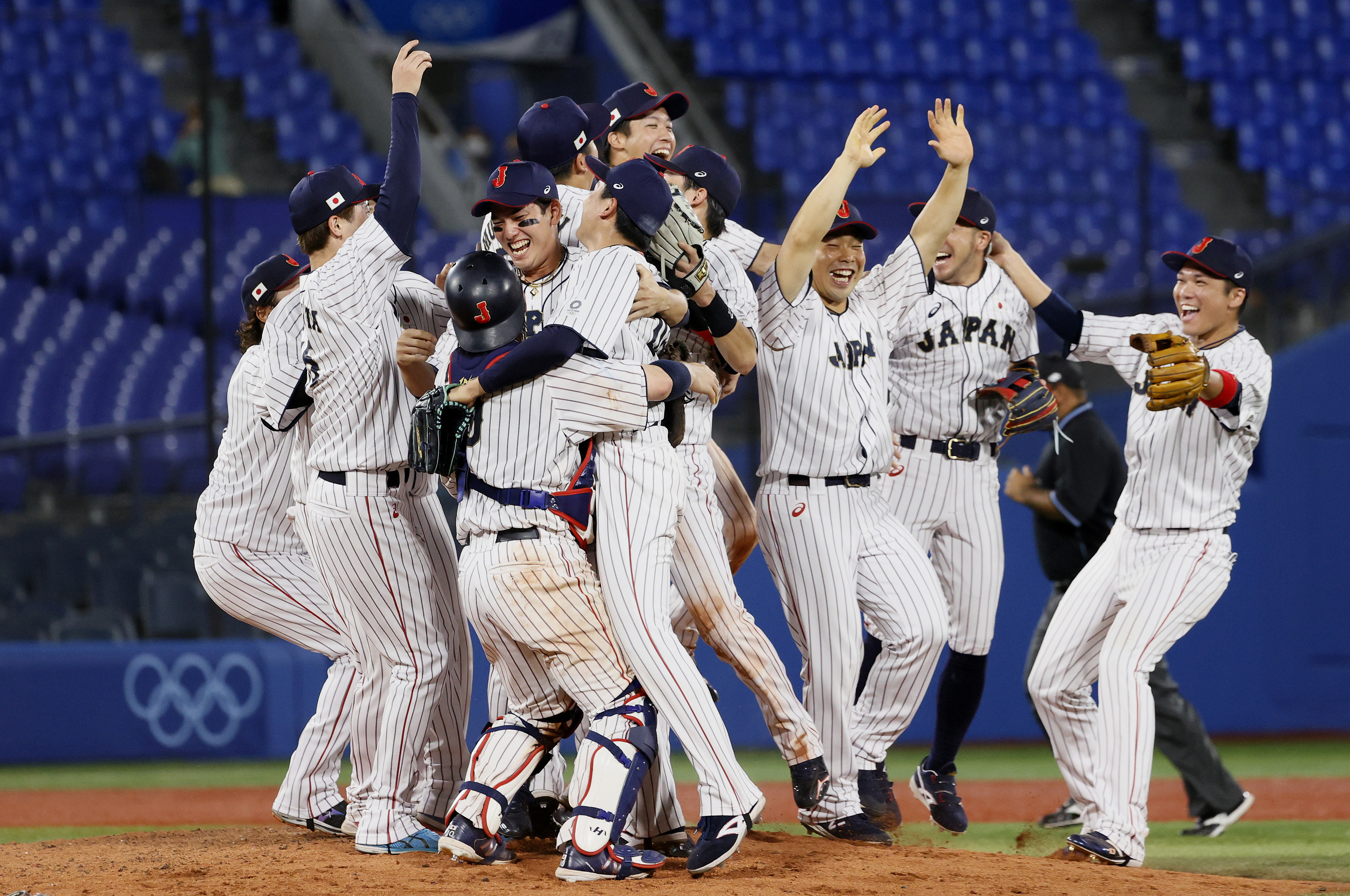 Japanese Olympic baseball team celebrates on the field, hugging and cheering