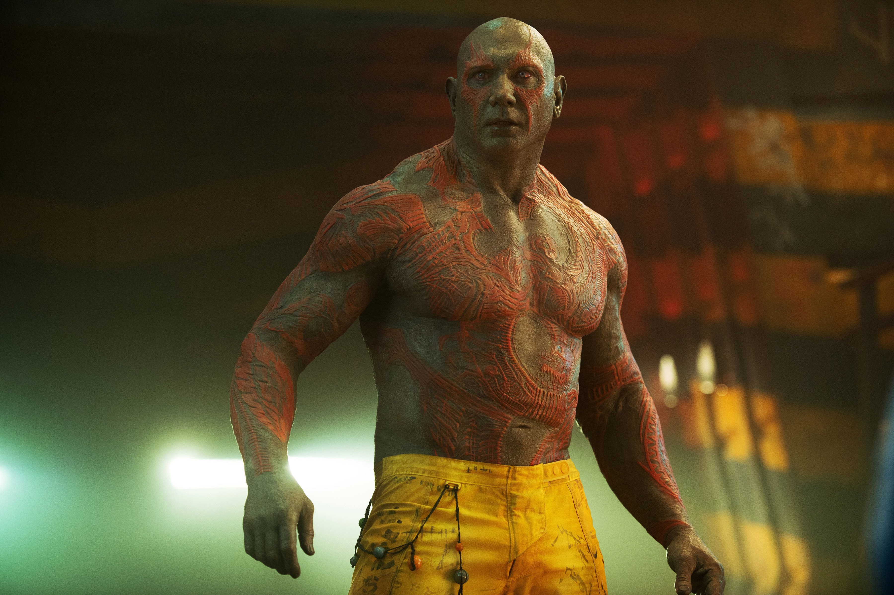 Dave Bautista as Drax wearing yellow pants, shirtless with red markings, in a scene from "Guardians of the Galaxy"