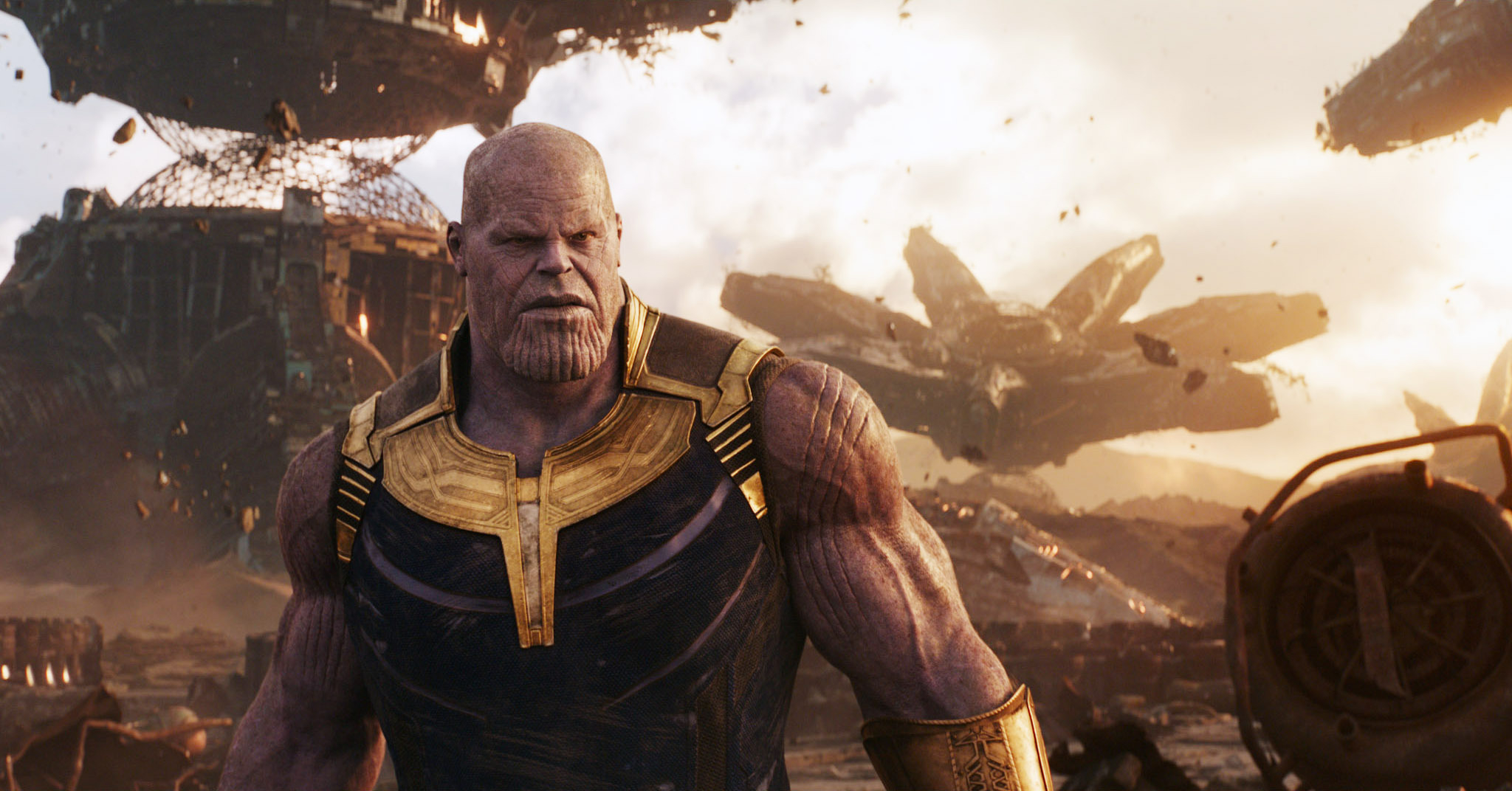 Thanos stands amid wreckage with spaceships in the background in a scene from "Avengers: Infinity War"