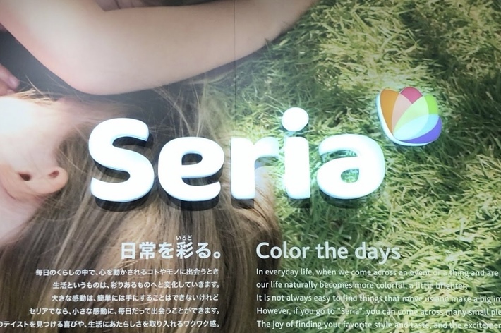 2人の子供が芝生の上で寝転んでいる。テキストには「日常を彩る。」というタイトルと、セリアの案内が書かれている。