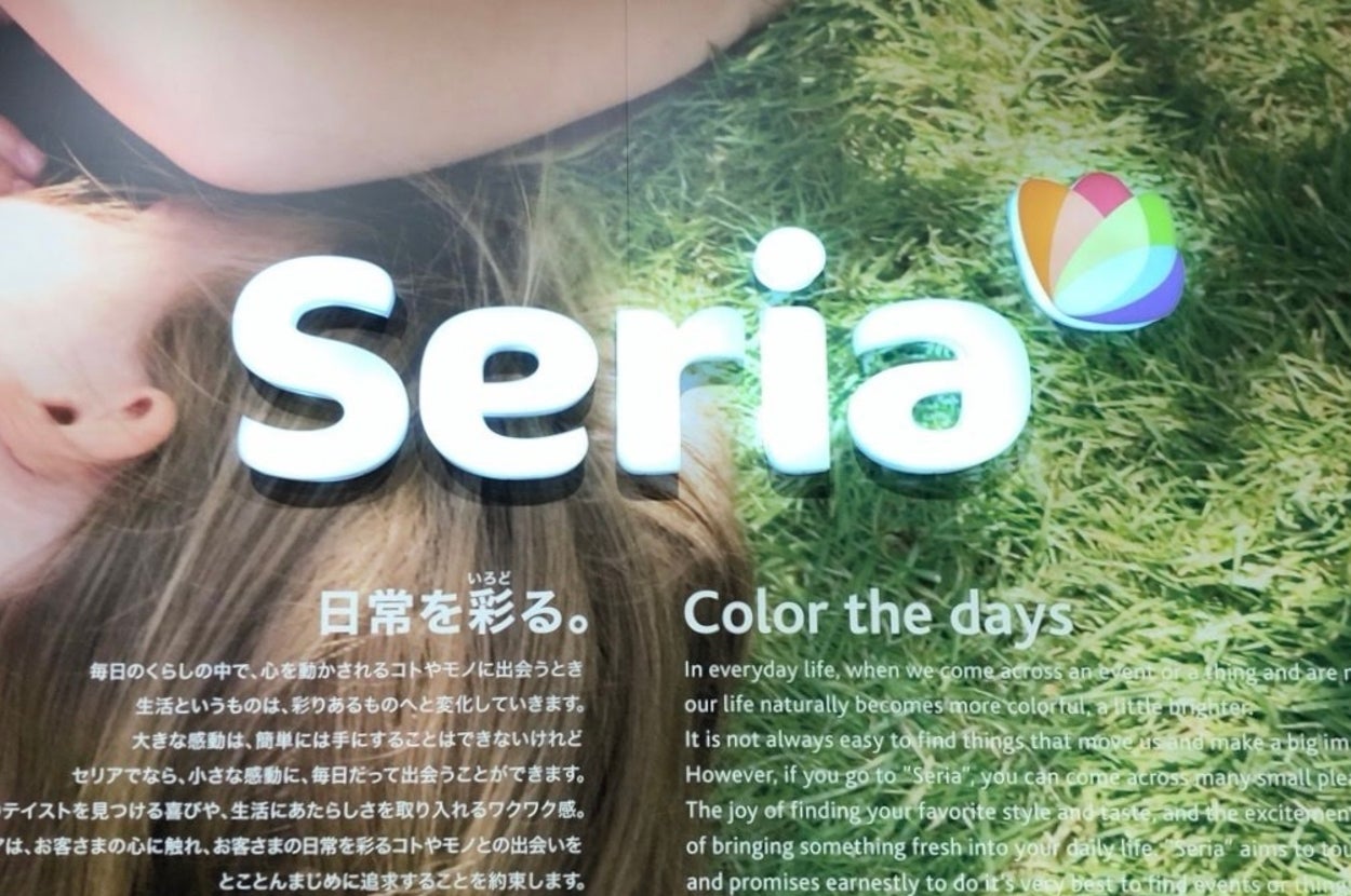 2人の子供が芝生の上で寝転んでいる。テキストには「日常を彩る。」というタイトルと、セリアの案内が書かれている。