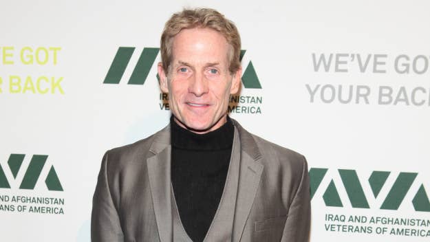 Skip Bayless, wearing a sleek suit and turtleneck, attends an event