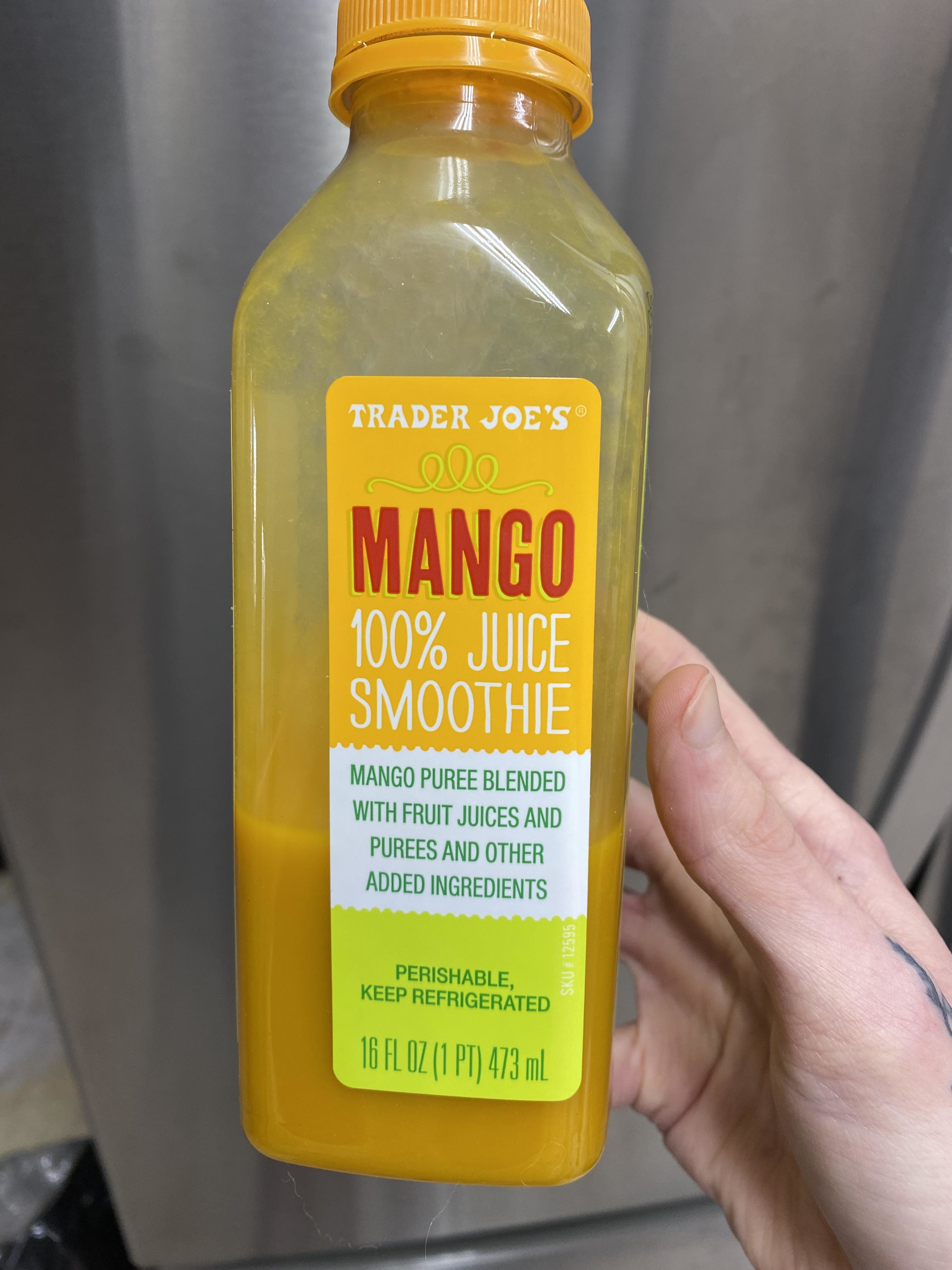 Hand holding a bottle of Trader Joe's Mango 100% Juice Smoothie.