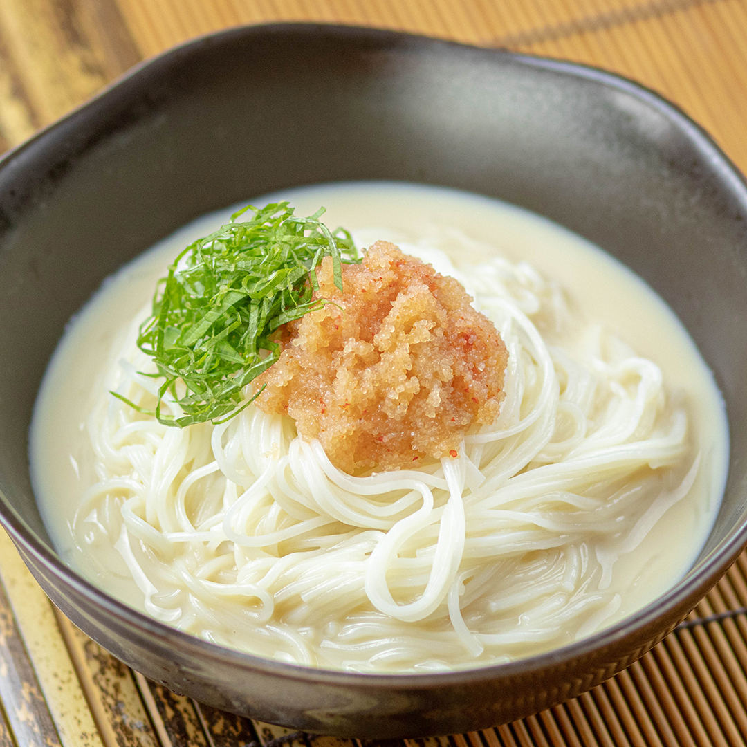 クリーミーなスープにそうめんが入った一杯、トッピングにはネギと明太子が乗っている。